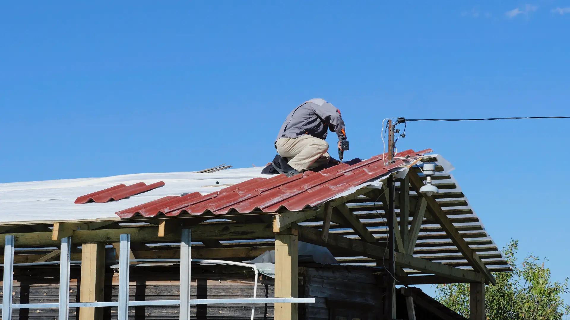 Roofing expert repairing a roof by drilling screws